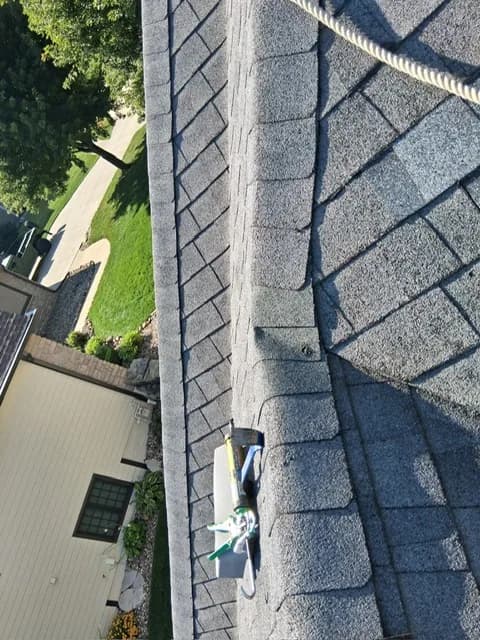 Roof ridge line with a caulking gun resting on it during resealing