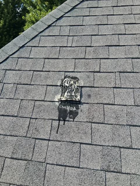 Old tar sealant patch around a roof penetration, found during inspection