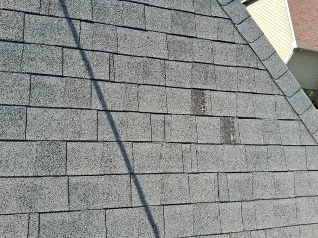 Cracked and broken shingles found on a roof before repair